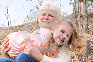 Loving cute granddaughter hugging her grandmother. Happy family.  Having good times with grandparent outdoors