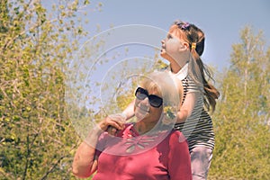 Loving cute granddaughter hugging her grandmother. Happy family.  Having good times with grandparent outdoors