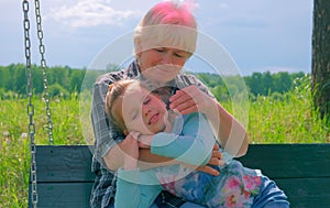 Loving cute granddaughter hugging her grandmother. Happy family.  Having good times with grandparent outdoors