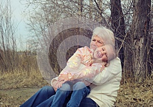 Loving cute granddaughter hugging her grandmother. Happy family.  Having good times with grandparent outdoors