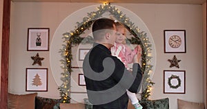 Loving dad dancing with daughter at Christmas.
