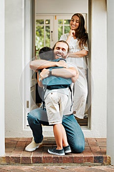 Loving dad hug and embrace son, love from father to son or parents saying goodbye to child on front porch at home. Happy