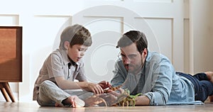 Loving dad and preschool child son playing dinosaurs at home
