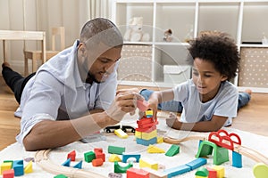 Loving dad and son engaged in game with construction cubes