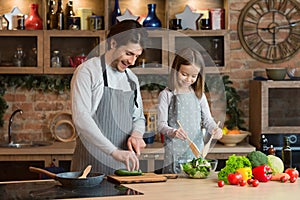 Loving dad teaching his little daughter to cook healthy food