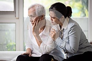 Loving daughter embracing comforting and consoling the old elderly, depressed stressed senior woman contemplating,afraid and