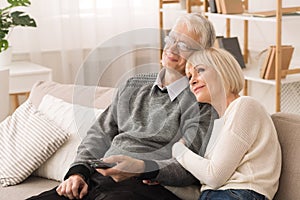 Loving Elderly Couple Watching TV, Resting At Home