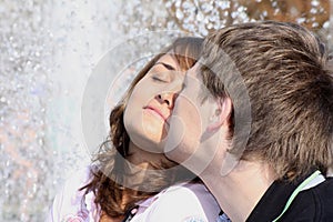 Loving(enamoured) couple kisses against a fountain