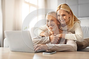 Loving european retired couple planning vacation together, using laptop