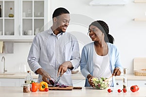 Loving expecting black couple enjoying cooking together