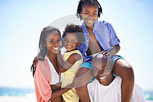 Loving family have a great time on the beach. An african american family enjoying a day out on the beach.