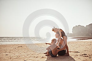 Loving family looking at the ocean from a sandy beach