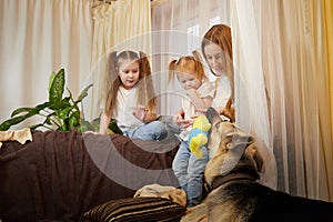 Loving family with mother, daughter sisters and big dog in living room. Woman mom, small child girl, female teenager who