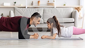 Loving father and daughter planking together at home