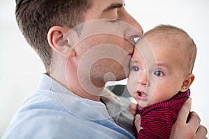 Loving Father Giving 9 Month Old Baby Son A Kiss