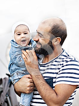 A loving father holds a child in his arms. Emotional photo.