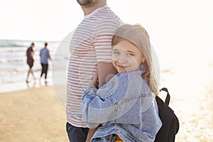 Loving father hugging his adorable little daughter on beach, dad and child spending time outdoors together