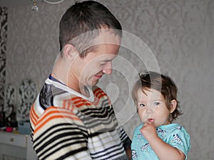 Loving father hugs the child in his arms. Baby 0-1 year old. Fatherly love. The relationship of father and son. A loving father