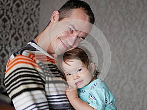 Loving father hugs the child in his arms. Baby 0-1 year old. Fatherly love. The relationship of father and son. A loving father