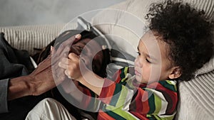 Loving father playing with his son on the sofa