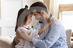 Loving father and small daughter cuddle sharing close moment