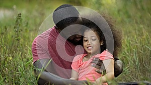 Loving father tenderly hugging his tiny daughter, spending time together outdoor