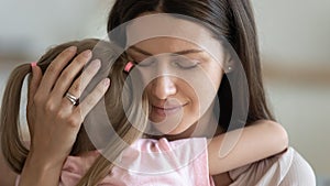 Loving foster parent mom hugging little kid daughter giving comfort