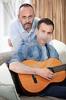 loving gay couple resting with guitar photo