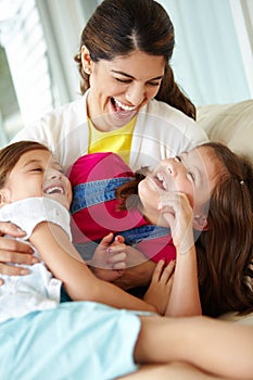 Loving the good times together. A mother and her two daughters sharing playful laugh together on the porch.