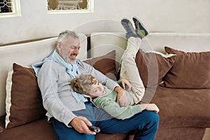 Loving grandpa. Portrait of a happy grandfather and excited grandson embracing, having fun and playing while relaxing on