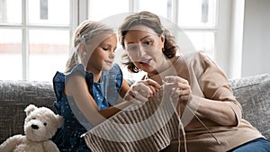 Loving granny teach granddaughter knitting with needles