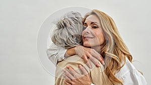 Loving grownup woman daughter embrace old mother