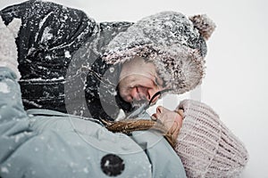 Loving guy and girl are lieing in the snow. Young happy couple walking in winter