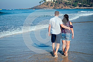 Loving happy couple walking along the beach. Romantic vacation happy honeymoon