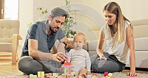 Loving, happy family, married couple is spending time with son, building a structure of wooden