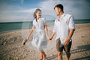 Loving happy young couple walking on the beach. Summer vacation