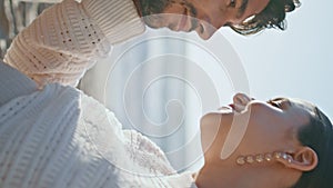 Loving husband kissing tummy pregnant wife at sunset sea coast vertical close up