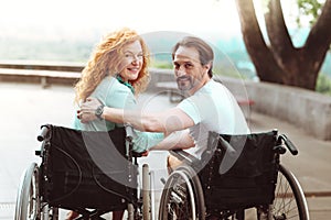 Loving incapacitated couple looking into camera and smiling