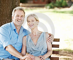 Loving and laughing together. Loving mature couple spending time together while outdoors in a park.