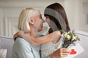 Loving little girl congratulate happy grandmother with special occasion