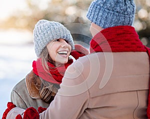 Loving man pulling down his laughing girlfriend ice hat