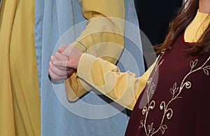 loving married couples holding hands in medieval clothes during  reenactment