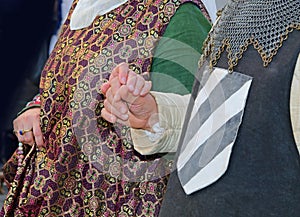 loving married couples holding hands in medieval clothes during reenactment