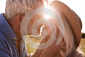 Loving Mature Couple In Countryside About To Kiss Against Flaring Sun