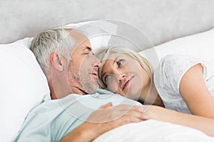 Loving mature couple lying in bed