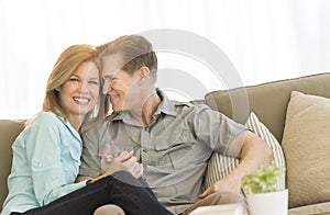 Loving Mature Couple Sitting On Sofa At Home