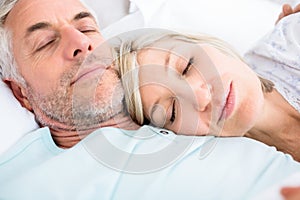 Loving mature couple sleeping in bed