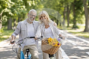 Loving Mature Spouses Posing At Camera While Riding Bicycles In Park