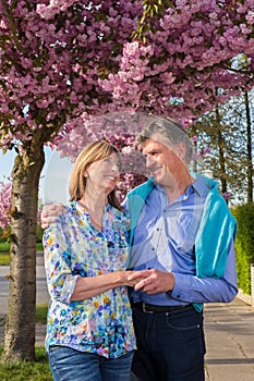 Loving middle-aged couple in a spring street.