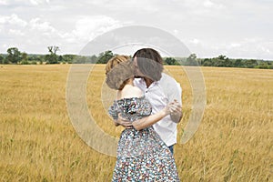 Loving middle-aged couple standing in field in summer